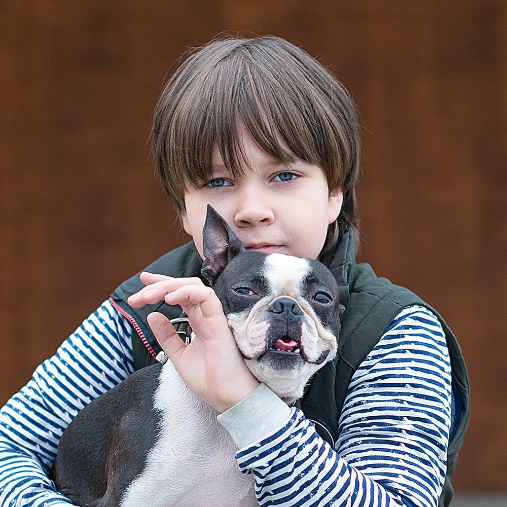 A boy lovingly holding his dog, representing the benefits of acupuncture for dogs in New Jersey.
